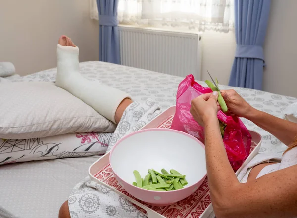 Woman with broken leg preparing food in bedroom. Close up
