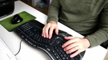 Avrupalı bir adam klavyede bir e-posta yazmayı öğrenirken, e-öğrenim yazılımı ev işyeriyle öğrenim ve metin otomasyonunda ilerleme olarak iki parmak sisteminden on parmak sisteminin öğrenildiğini gösterir.