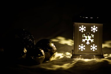 Romantik Noel ışıkları gecenin ilerleyen saatlerinde karanlık kutsal geceyi aydınlatıyor. Romantik Noel süsleri ve Noel süslemeleri ile.