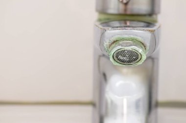 Banyoda kireçlenmiş krom kabzası olarak eski pullu musluk sızıntıyı durdurmak için temizlik maddesiyle bakım ve kireçlenmeden arındırma ve damlacık yoksulluğu ile eski bakterinin hijyen bakterisini iyileştirmeye ihtiyaç duyar.