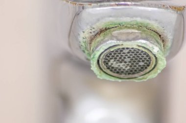 Banyoda kireçlenmiş krom kabzası olarak eski pullu musluk sızıntıyı durdurmak için temizlik maddesiyle bakım ve kireçlenmeden arındırma ve damlacık yoksulluğu ile eski bakterinin hijyen bakterisini iyileştirmeye ihtiyaç duyar.