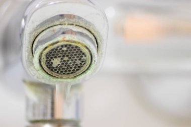 Banyoda kireçlenmiş krom kabzası olarak eski pullu musluk sızıntıyı durdurmak için temizlik maddesiyle bakım ve kireçlenmeden arındırma ve damlacık yoksulluğu ile eski bakterinin hijyen bakterisini iyileştirmeye ihtiyaç duyar.
