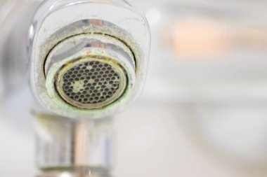 Banyoda kireçlenmiş krom kabzası olarak eski pullu musluk sızıntıyı durdurmak için temizlik maddesiyle bakım ve kireçlenmeden arındırma ve damlacık yoksulluğu ile eski bakterinin hijyen bakterisini iyileştirmeye ihtiyaç duyar.