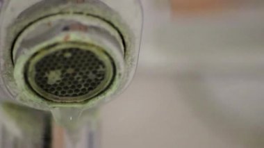 Banyoda kireçlenmiş krom kabzası olarak eski pullu musluk sızıntıyı durdurmak için temizlik maddesiyle bakım ve kireçlenmeden arındırma ve damlacık yoksulluğu ile eski bakterinin hijyen bakterisini iyileştirmeye ihtiyaç duyar.