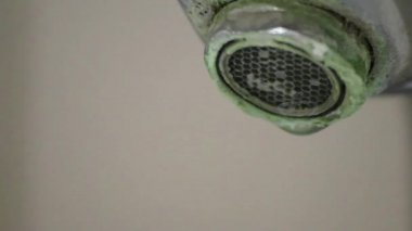 Banyoda kireçlenmiş krom kabzası olarak eski pullu musluk sızıntıyı durdurmak için temizlik maddesiyle bakım ve kireçlenmeden arındırma ve damlacık yoksulluğu ile eski bakterinin hijyen bakterisini iyileştirmeye ihtiyaç duyar.