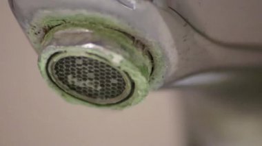 Banyoda kireçlenmiş krom kabzası olarak eski pullu musluk sızıntıyı durdurmak için temizlik maddesiyle bakım ve kireçlenmeden arındırma ve damlacık yoksulluğu ile eski bakterinin hijyen bakterisini iyileştirmeye ihtiyaç duyar.