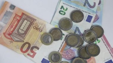 Avro parasını avro banknotları ve avro sikkeleriyle yakalayan Avrupalı açgözlü bir adam özel zevk ve zevk için ellerini beyaz masanın üzerine koyuyor ya da başkalarının hırsız ve para ticaretini soyuyor.