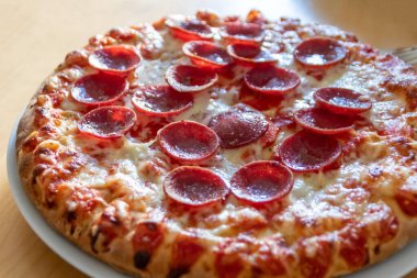 Peynir ve domates soslu, yakın planda salamlı lezzetli pizza. Lezzetli İtalyan yemeği ve aç gençler için diyet fast food. Parça parça besin atıştırmalıkları.