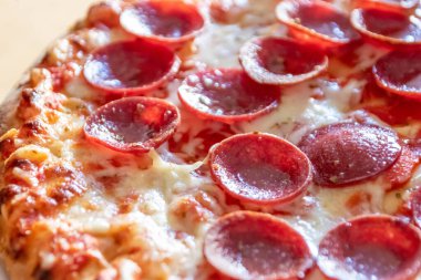 Peynir ve domates soslu, yakın planda salamlı lezzetli pizza. Lezzetli İtalyan yemeği ve aç gençler için diyet fast food. Parça parça besin atıştırmalıkları.