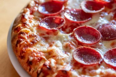 Peynir ve domates soslu, yakın planda salamlı lezzetli pizza. Lezzetli İtalyan yemeği ve aç gençler için diyet fast food. Parça parça besin atıştırmalıkları.