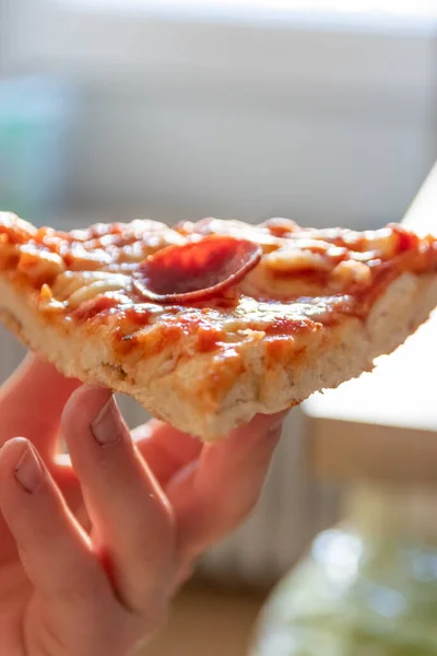 ホットスチームとおいしいチーズのピザサラミの子供の手を保持する部分は マクロビューで喜びを食べる食事のためのカロリーと不健康なスナックとしてクローズアップショットファーストフードの食事 — ストック写真