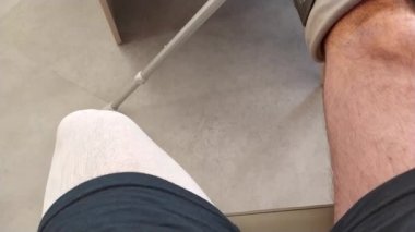 Avrupalı cadı Achilles tendonu yırtıldı. Hastanenin bekleme odasında özel bir ayakkabı ve koltuk değnekleriyle acil durum sonrası rehabilitasyon için boş bekleme odasında bekliyor.