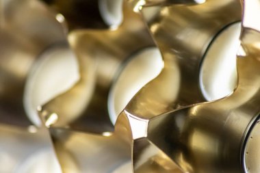 Parlak yansımaları ve harmonik şekilleri olan gümüş ve altın metal yüzeyin soyut altın arkaplan desenli makro modeli. Daireler ve koniler zarif fütürist tasarım grafiksel dalgalar.