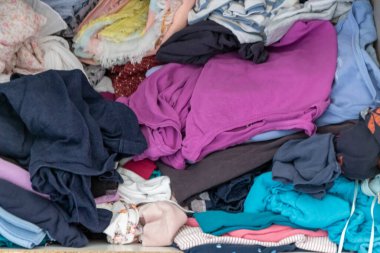 Karmaşık gardırop ve dağınık gardırop, alışveriş bağımlılığı olan birçok kadın kıyafeti ve buruşuk çamaşırları dağınık bir moda yığınına depolanmış kazak, gömlek ve pantolon gibi birçok giysi gösteriyor.