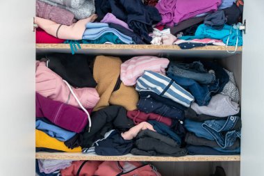 Karmaşık gardırop ve dağınık gardırop, alışveriş bağımlılığı olan birçok kadın kıyafeti ve buruşuk çamaşırları dağınık bir moda yığınına depolanmış kazak, gömlek ve pantolon gibi birçok giysi gösteriyor.