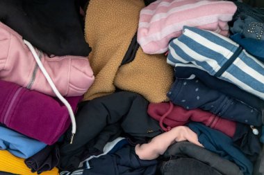 Karmaşık gardırop ve dağınık gardırop, alışveriş bağımlılığı olan birçok kadın kıyafeti ve buruşuk çamaşırları dağınık bir moda yığınına depolanmış kazak, gömlek ve pantolon gibi birçok giysi gösteriyor.