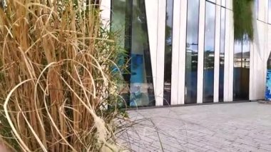 DÜKSELDORF, GERMANY - 14 Temmuz 2022: Düsseldorf, Almanya 'daki modern iş binası, organik cam cepheli ve öngörülü mimarisi ile ön cephelerinde bitkiler bulunan zarif bina cepheleri