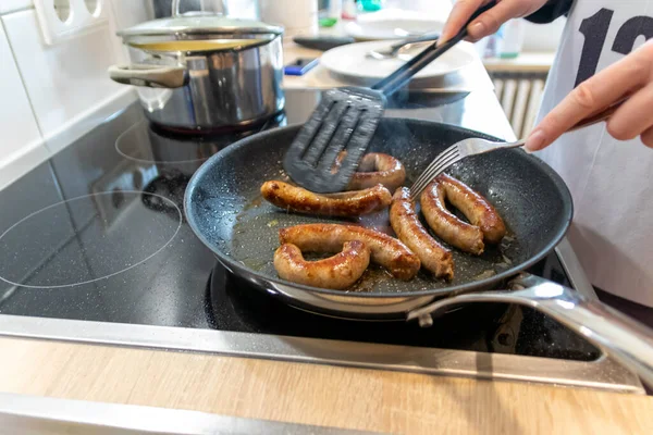 Woman Cooking Sausages Pan Kitchen Cooking Plate Fork Black Spatula — Foto de Stock