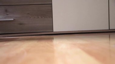 Male hand picking up heavy barbell rolling into view for heavy weight lifting workout at home on floor as bodybuilding exercise to train arm muscles like biceps and triceps strength physical fitness