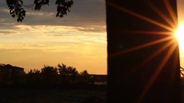 Golden sky with sun rays and lens flare shows solar energy with electricity tower pylon silhouette in golden sunset and orange sky for sustainable energy or renewable resources from dusk till dawn sun