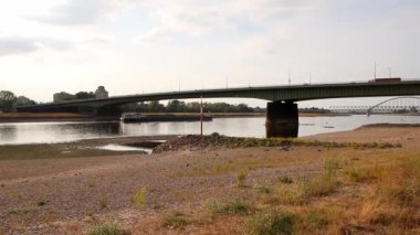 Extreme low water line in river Rhine Dsseldorf in extreme drought with no rainfall causes drying out riverbed and low tide shows global warming and climate change with dry riverbank water shortage