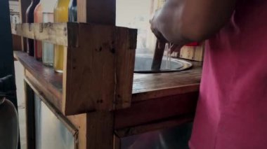 Tavuklu erişte satıcısı ahşap çubuklarla pişmiş erişteleri karıştırıyor..