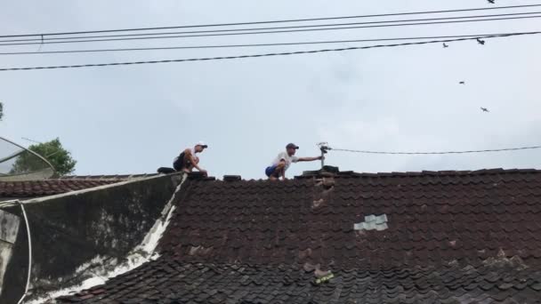 Young People Renovating Roof Leaked Due Strong Winds — Stock Video