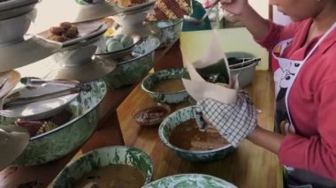 Geleneksel Endonezya yemeği olan Nasi Padang 'ı satan Endonezyalı bir kadın alıcılar için yemek hazırlıyor..