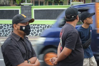 A man wearing a mask is watching during a healthy walk