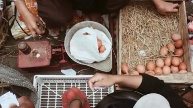 Asian woman selling eggs serving egg buyers in traditional market.
