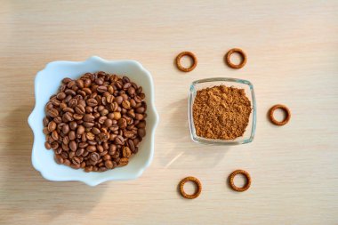Masada bir avuç kahve çekirdeği ve kakao tozlu cam bir tabak var. Üst görünüm