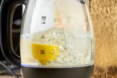 Yarım sarı limon, cam bir su ısıtıcısında kaynatılır.