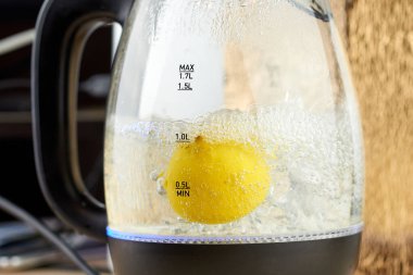 Yarım sarı limon, cam bir su ısıtıcısında kaynatılır.