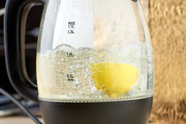 Yarım sarı limon, cam bir su ısıtıcısında kaynatılır.