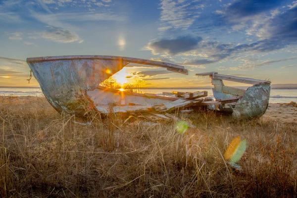 Старая лодка против заката солнца — стоковое фото