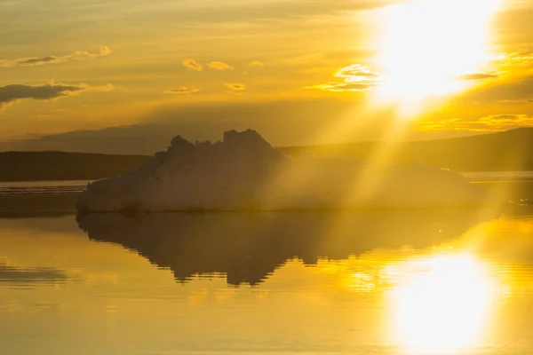 De smeltende ijsberg op lente bergmeer in de ondergaande zon. — Stockfoto