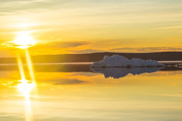 L'iceberg qui fond sur le lac de montagne printanier au soleil couchant . — Photo