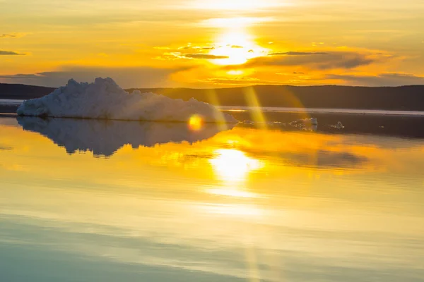 Bahar dağ gölü batan güneşin içinde eriyen buzdağı. — Stok fotoğraf