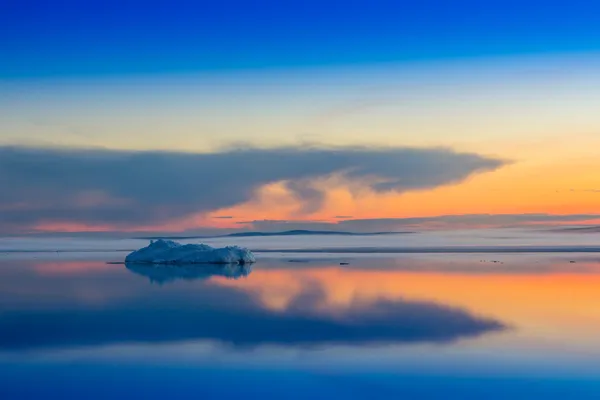 O iceberg derretendo no lago de montanha de primavera no pôr-do-sol . — Fotografia de Stock