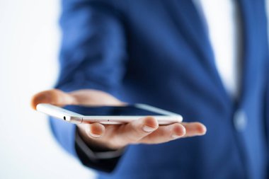 Genç adam telefonu tutuyor.