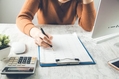 Masasında hesap makinesi olan kadın el dokümanı