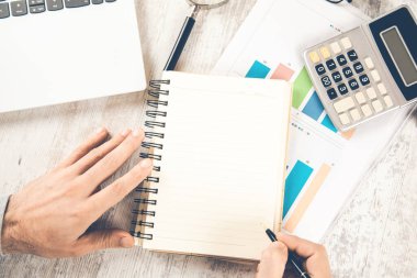 Masasında bilgisayar olan bir not defteri.