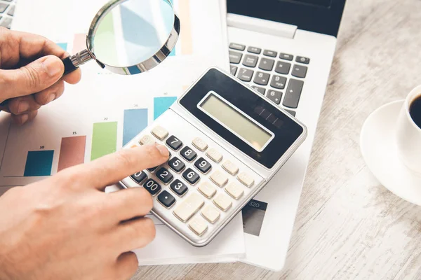 Mann Lupe Mit Graph Und Taschenrechner Auf Dem Schreibtisch — Stockfoto