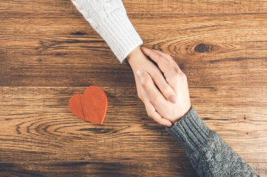 Erkek ve kadın el ele tutuşur masada