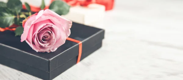 玫瑰在木制桌子上的黑色礼品盒上 — 图库照片