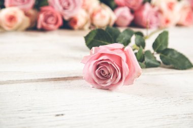 Ahşap masada pembe güller