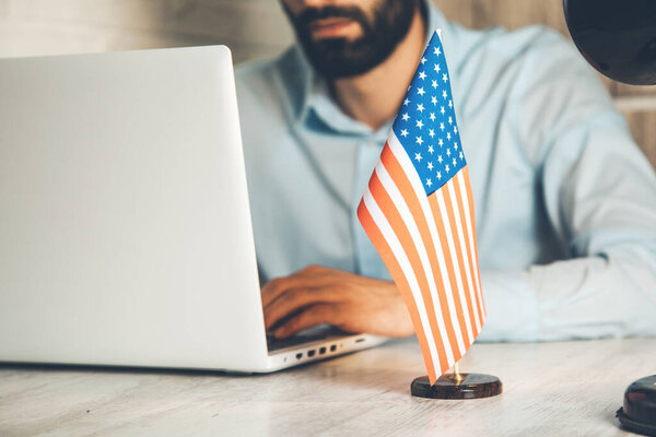man working in computer with american flag on desk