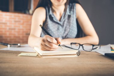 Kadın not defteri masanın üstünde.