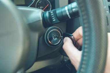 Genç adam arabanın anahtarını tutuyor.