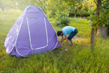 Ormanda kamp çadırında genç bir adamla. 